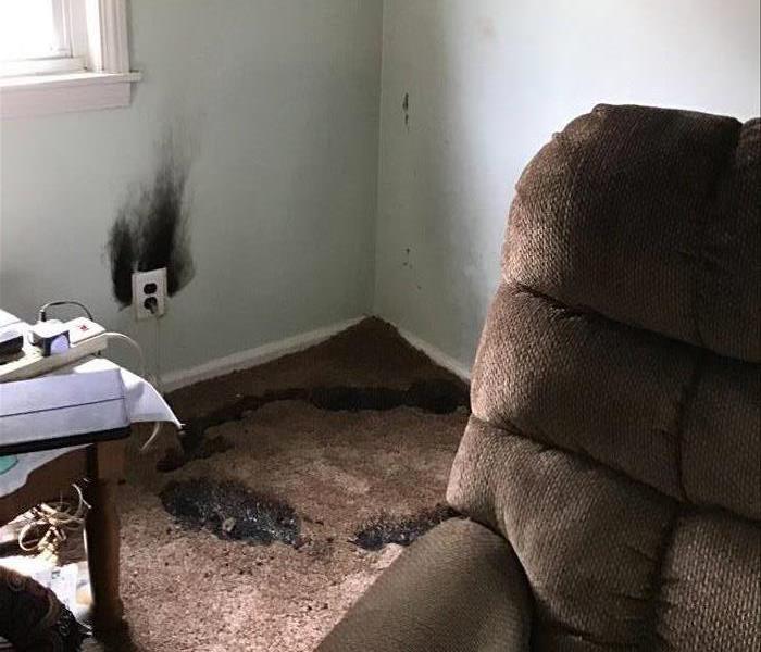 Customers living room with burned carpet and soot on walls from a fire